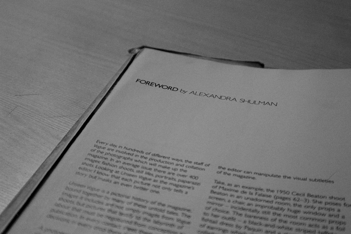 Un libro aperto posato su un tavolo di legno grezzo.